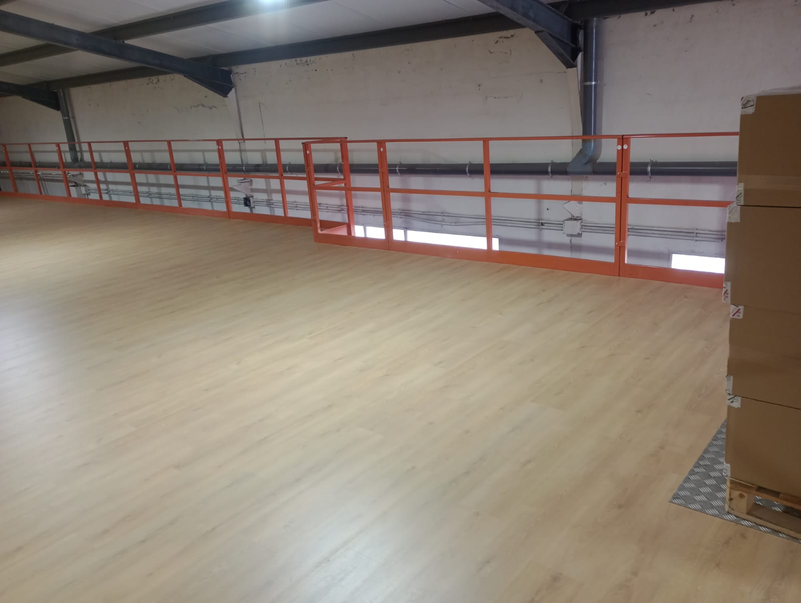 Altillo de nave con suelo laminado limpio y barandillas tras servicio Aliserv